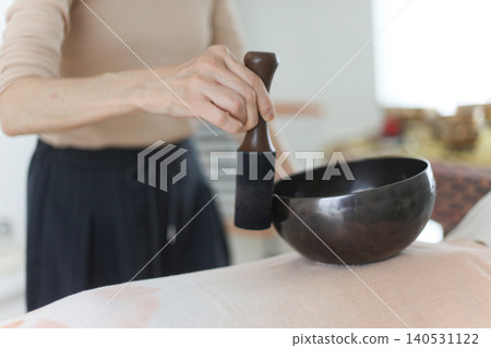 Woman playing a singing bowl 140531122