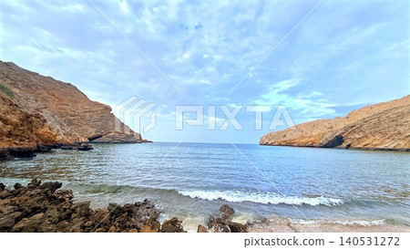 Secluded rocky cove with calm sea and cloudy sky Secluded rocky cove with calm sea and cloudy sky 140531272