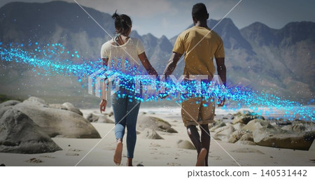 Walking couple holding hands heading to shore, beach, white knit, mustard tee, blue particle ribbon Walking couple holding hands heading to shore, beach, white knit, mustard tee, blue particle ribbon 140531442