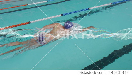 Swimming man freestyling in lap pool, wearing dark cap and briefs, lane ropes and wave graphic Swimming man freestyling in lap pool, wearing dark cap and briefs, lane ropes and wave graphic 140531464