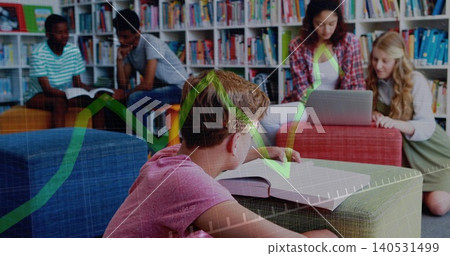 Leaning boy in pink tee reading textbook on ottoman in school library, with laptop, shelves, graph Leaning boy in pink tee reading textbook on ottoman in school library, with laptop, shelves, graph 140531499