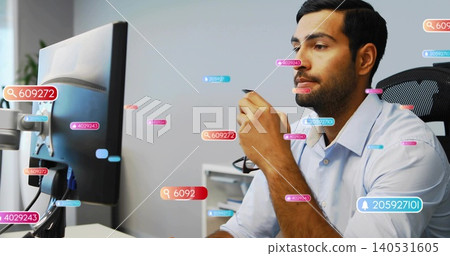 Holding eyeglasses, Asian man wearing blue shirt leaning toward monitor in office, data overlays Holding eyeglasses, Asian man wearing blue shirt leaning toward monitor in office, data overlays 140531605