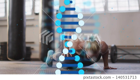 Woman in tank and leggings performing push-up in gym, with barbell, punching bags, DNA overlay Woman in tank and leggings performing push-up in gym, with barbell, punching bags, DNA overlay 140531713