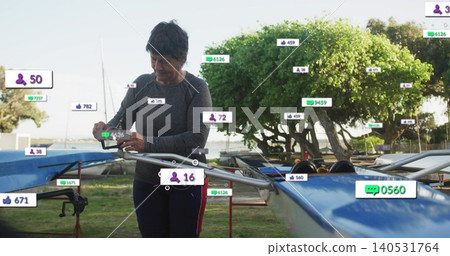 Checking senior in athletic top viewing phone near rigging at launch, blue shell with overlays Checking senior in athletic top viewing phone near rigging at launch, blue shell with overlays 140531764