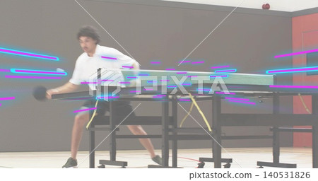 Lunging adult male in white-shirt swinging paddle toward folded table and net in gym, motion blur 140531826