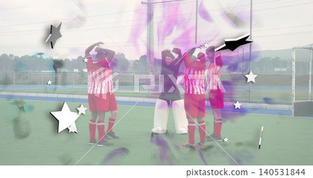Standing five hockey players in striped jerseys raising hands on turf pitch, with goal net overlays Standing five hockey players in striped jerseys raising hands on turf pitch, with goal net overlays 140531844