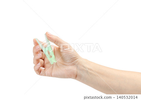 Woman's hand holding a clothespin on a white background Woman's hand holding a clothespin on a white background 140532014