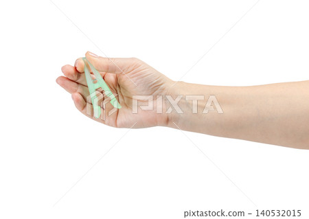 Woman's hand holding a clothespin on a white background Woman's hand holding a clothespin on a white background 140532015