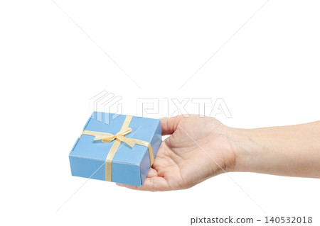 Woman's hand holding a gift box on her palm with the white background. Woman's hand holding a gift box on her palm with the white background. 140532018