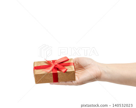 Woman's hand holding a gift box on her palm with the white background. Woman's hand holding a gift box on her palm with the white background. 140532023