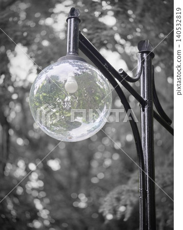 Close-up of a vintage street lamp with a round glass globe in a park Close-up of a vintage street lamp with a round glass globe in a park 140532819
