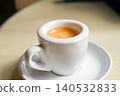 Minimalist Espresso with crema in White Coffee Cup on Saucer, Top View 140532833