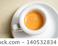 Minimalist Espresso with crema in White Coffee Cup on Saucer, Top View 140532834