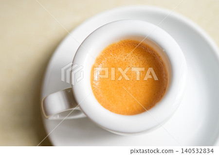 Minimalist Espresso with crema in White Coffee Cup on Saucer, Top View Minimalist Espresso with crema in White Coffee Cup on Saucer, Top View 140532834