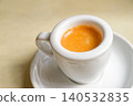 Minimalist Espresso with crema in White Coffee Cup on Saucer, Top View 140532835