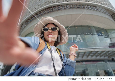Asian woman tourist taking selfie in modern city for travel blog 140532836