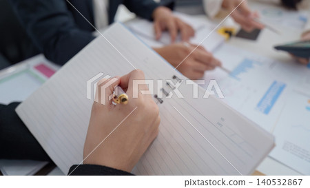 Business person taking notes during office meeting Business person taking notes during office meeting 140532867