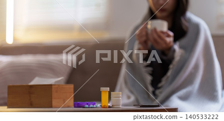 Medication and hot drink on table for sick person at home Medication and hot drink on table for sick person at home 140533222