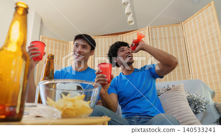 Asian and Southeast Asian men cheering football game with vuvuzela Asian and Southeast Asian men cheering football game with vuvuzela 140533241