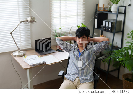 Asian man stretching and relaxing during work break at home office 140533282