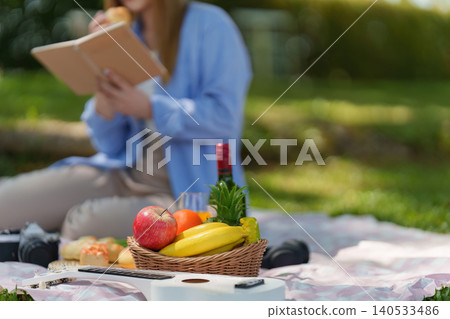 Spring outdoor picnic with healthy food, fruit basket, guitar, and reading Spring outdoor picnic with healthy food, fruit basket, guitar, and reading 140533486