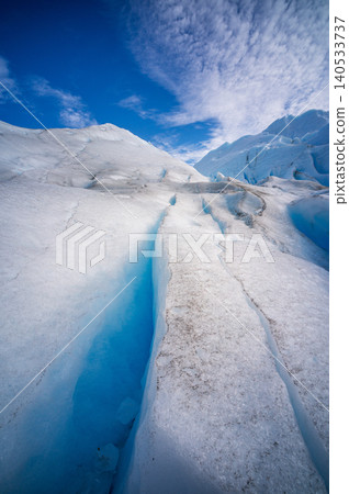Perito moreno glacier patagonia los glaciares national park, vivid blue crevasse and sunlit ice under dramatic sky Perito moreno glacier patagonia los glaciares national park, vivid blue crevasse and sunlit ice under dramatic sky 140533737
