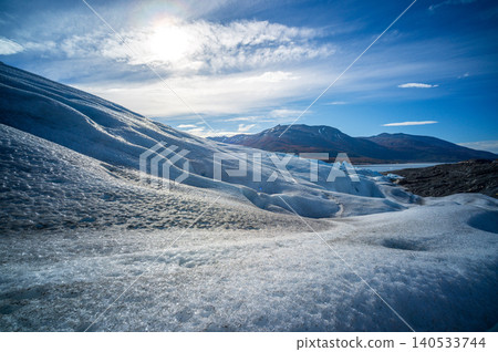 Perito moreno glaciers ice landscape under sun with mountain and blue sky over frozen patagonia wilderness 140533744