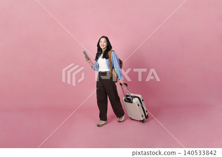 Asian woman in 20s with smartphone and luggage ready for travel Asian woman in 20s with smartphone and luggage ready for travel 140533842