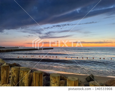 Wooden posts framing sunset seascape 140533908