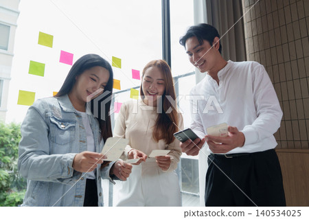 Asian UX UI designers collaborating on mobile application development in office. Asian UX UI designers collaborating on mobile application development in office. 140534025