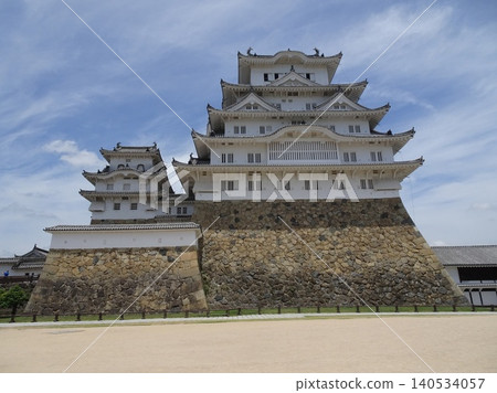 A panoramic view of Himeji Castle's main keep and west smaller keep, soaring against the blue sky, as seen from the Bizenmaru plaza. 140534057