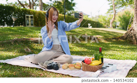 Asian woman making video call with smartphone in outdoor park for social connection Asian woman making video call with smartphone in outdoor park for social connection 140534102
