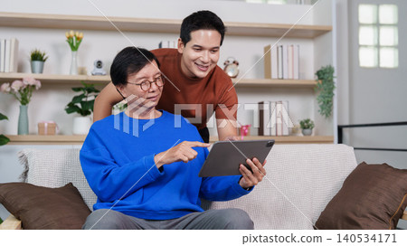 Asian senior man learning digital technology on tablet with younger man 140534171