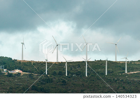 Renewable energy wind farm with modern turbines on a forested mountain Renewable energy wind farm with modern turbines on a forested mountain 140534323