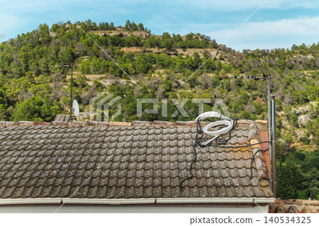 Rural rooftop with television antenna overlooking wooded valley and Mediterranean hills near Margalef village in Catalonia, Spain Rural rooftop with television antenna overlooking wooded valley and Mediterranean hills near Margalef village in Catalonia, Spain 140534325