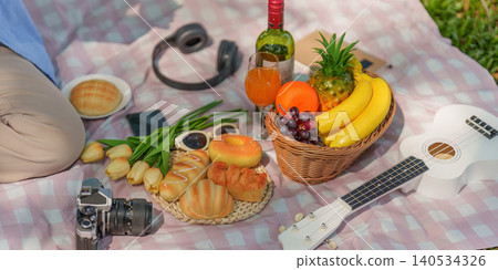 Outdoor picnic with fresh fruit, bread, and ukulele on a spring day Outdoor picnic with fresh fruit, bread, and ukulele on a spring day 140534326