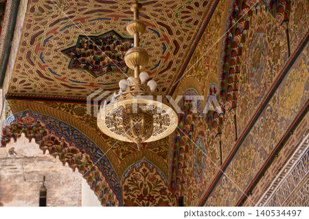 The interior of the Zaouia of Moulay Idriss II showcases its magnificent bronze chandelier and ornate ceilings in Fez 140534497