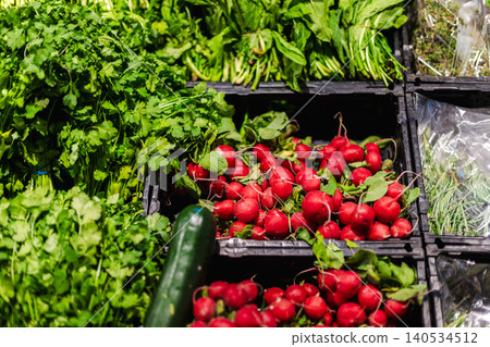 Fresh radishes and leafy greens displayed in supermarket produce section Fresh radishes and leafy greens displayed in supermarket produce section 140534512