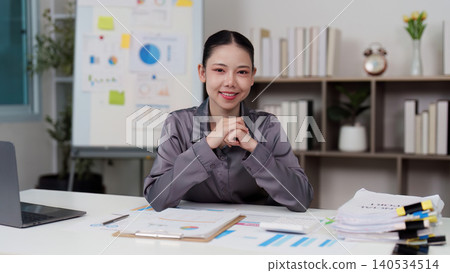 Confident Asian woman in her 20s or 30s smiling at a modern business office 140534514