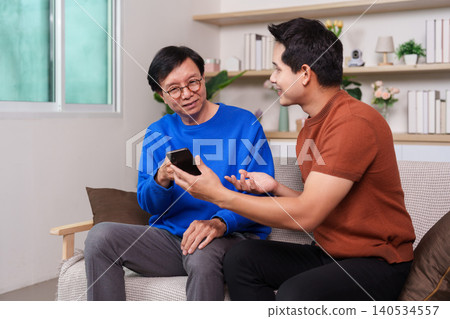 Asian senior man learning smartphone from younger man at home 140534557