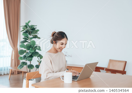 Beautiful young Asian woman working with laptop computer in living room. Work at home Beautiful young Asian woman working with laptop computer in living room. Work at home 140534564
