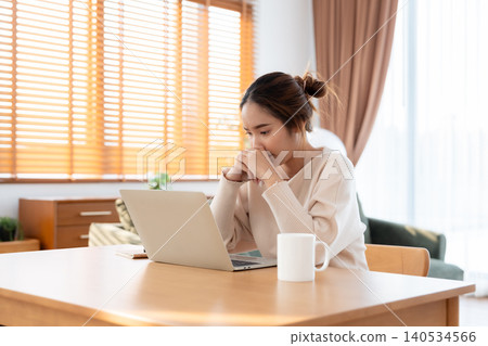 Asian woman are stressed, pain in their eyes, working on laptop in living room at home Asian woman are stressed, pain in their eyes, working on laptop in living room at home 140534566