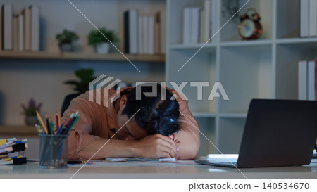 East Asian man suffering burnout and exhaustion sleeping on desk from overwork East Asian man suffering burnout and exhaustion sleeping on desk from overwork 140534670