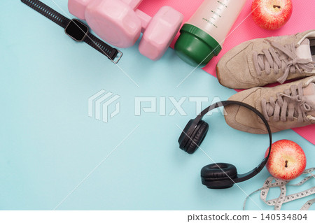 Fitness equipment flat lay with dumbbell smartwatch headphones apples 140534804
