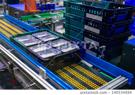 Modern automated food production line sorting ready to eat meal trays into industrial plastic baskets Modern automated food production line sorting ready to eat meal trays into industrial plastic baskets 140534894