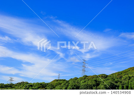 Power transmission towers against a blue sky: an image of power infrastructure. 140534908