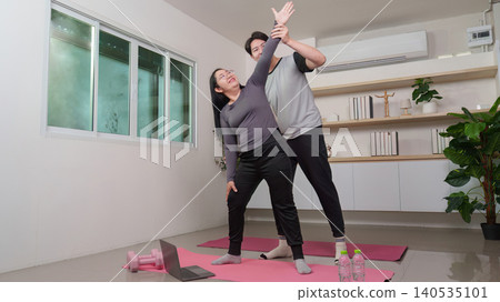 Asian man and woman doing home workout with personal trainer, healthy lifestyle. Asian man and woman doing home workout with personal trainer, healthy lifestyle. 140535101