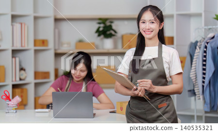 Confident Asian woman entrepreneur managing small online retail business Confident Asian woman entrepreneur managing small online retail business 140535321