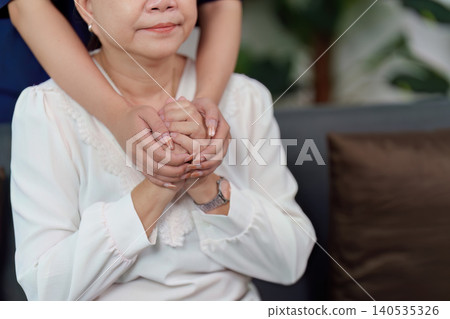 Asian doctor providing emotional support to senior woman patient hands Asian doctor providing emotional support to senior woman patient hands 140535326