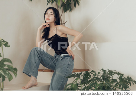 A woman wearing a swimsuit and denim outfit. 140535503